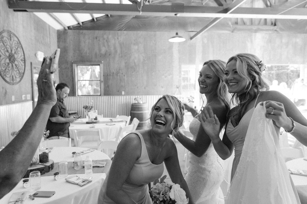 Bride taking photos with bridesmaids during reception