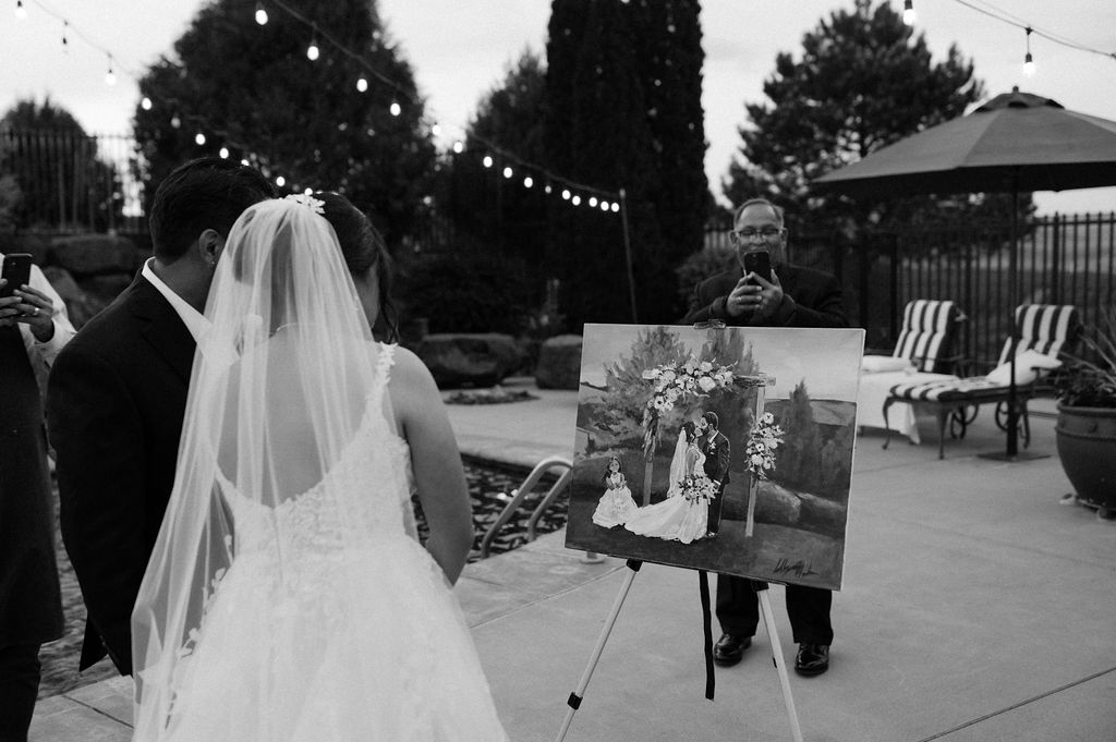 Bride and groom seeing their live wedding painting