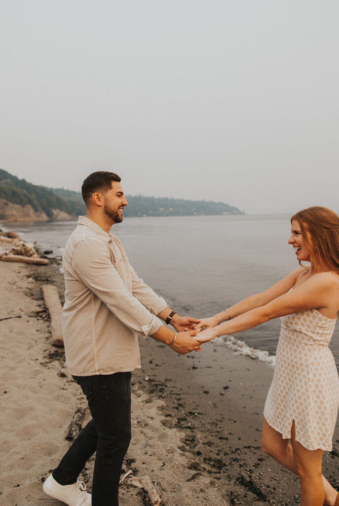 Playful Discovery park engagement photos with beach in the backdrop
