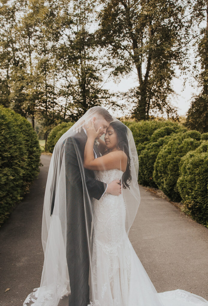 bride and groom under veil photo