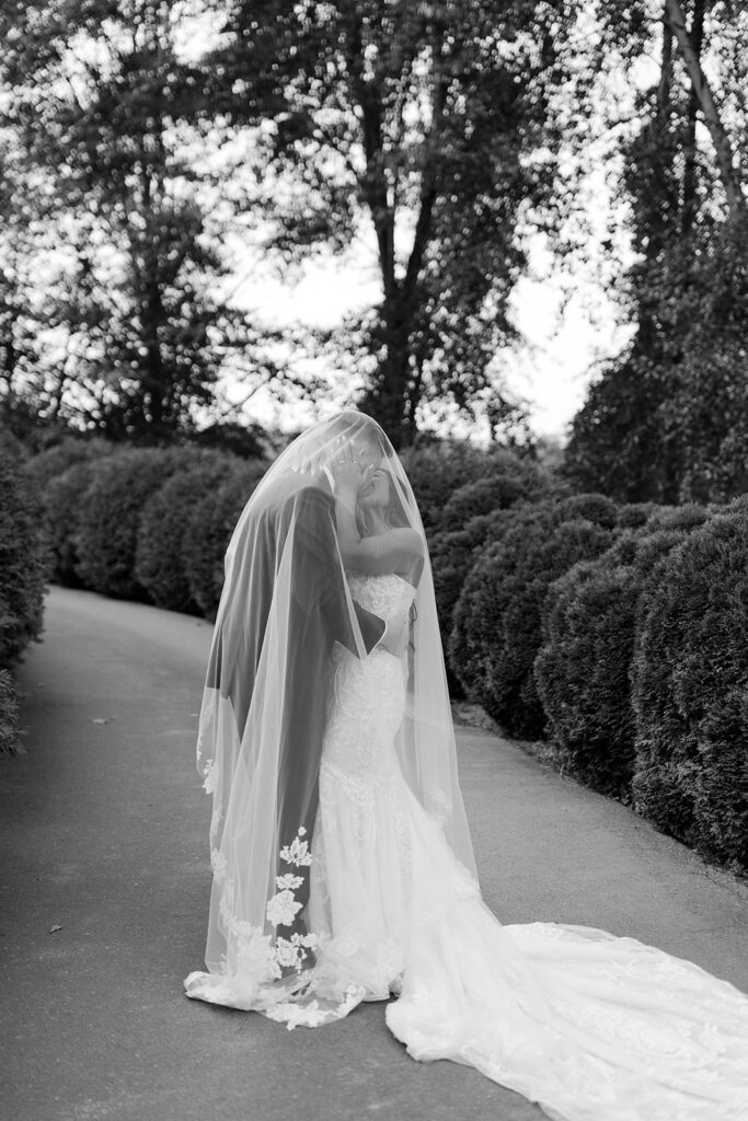 bride and groom under veil photo