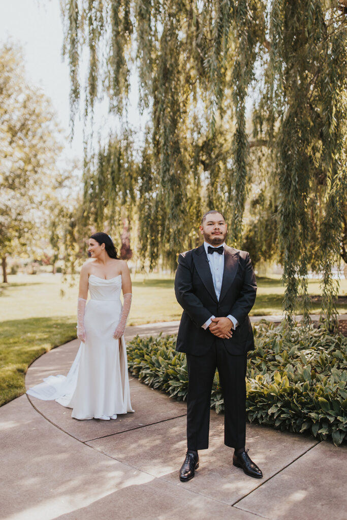 romantic bride and groom first look outdoors by a weeping willow