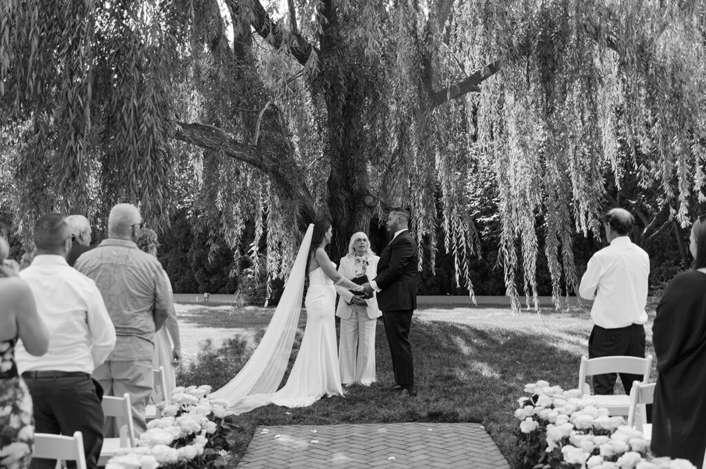 romantic outdoor wedding ceremony with a weeping willow in the backdrop at Promise Garden WA