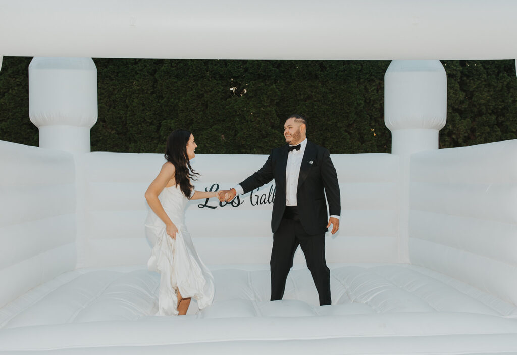 bride and groom in a white bouncy castle