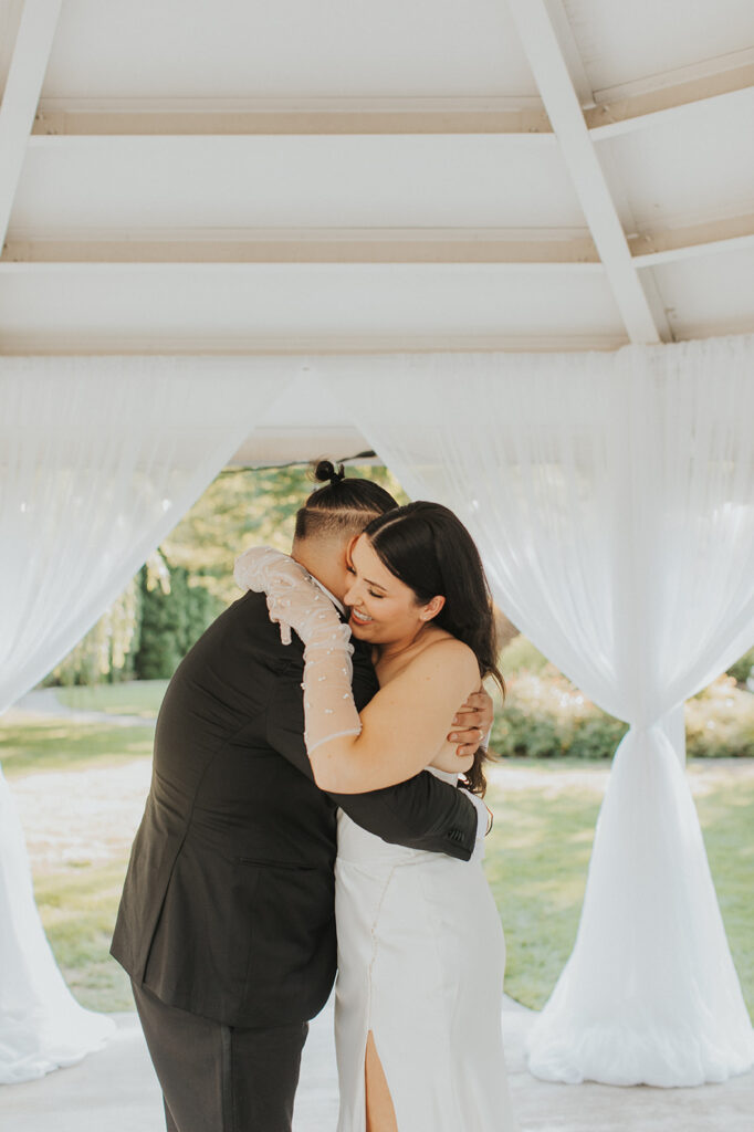 bride and groom first dance in a white gazebo