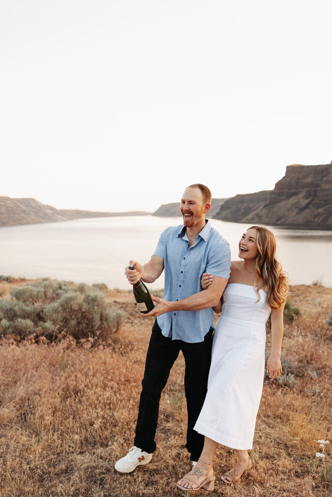 Couple celebrates with champagne during their summer engagement session