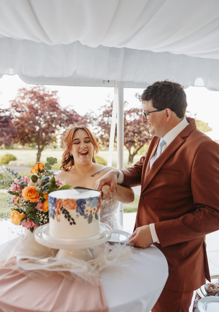 Couple cutting cake at their outdoor Wedding and Reception