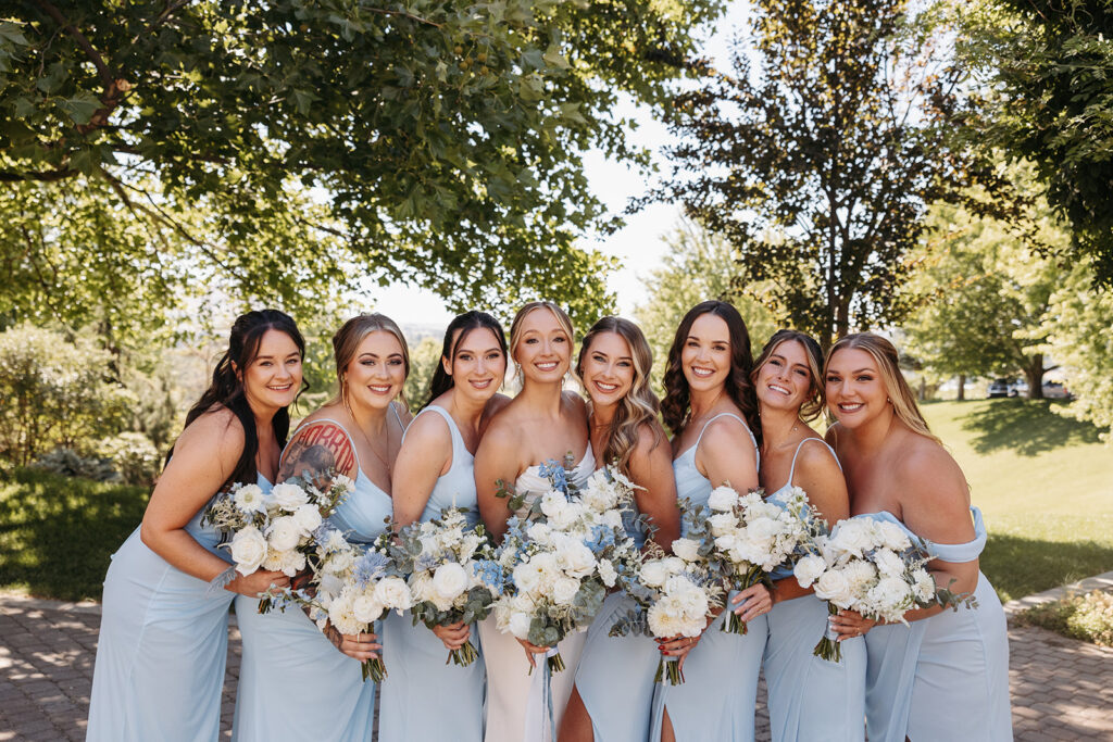 Bridesmaids stand at Terra Blanca Winery, with the scenic greenery providing a perfect backdrop.