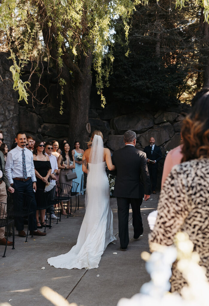 Summer ceremony at Terra Blanca Winery, with the bride walking down the aisle.