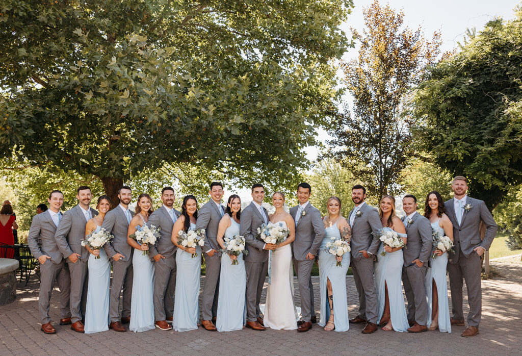 A joyful bridal party celebrates with the newlyweds at Terra Blanca Winery, with the scenic vineyards providing a perfect backdrop.