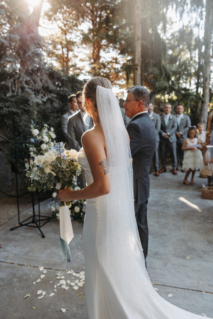 Summer ceremony at Terra Blanca Winery, with the bride walking down the aisle.