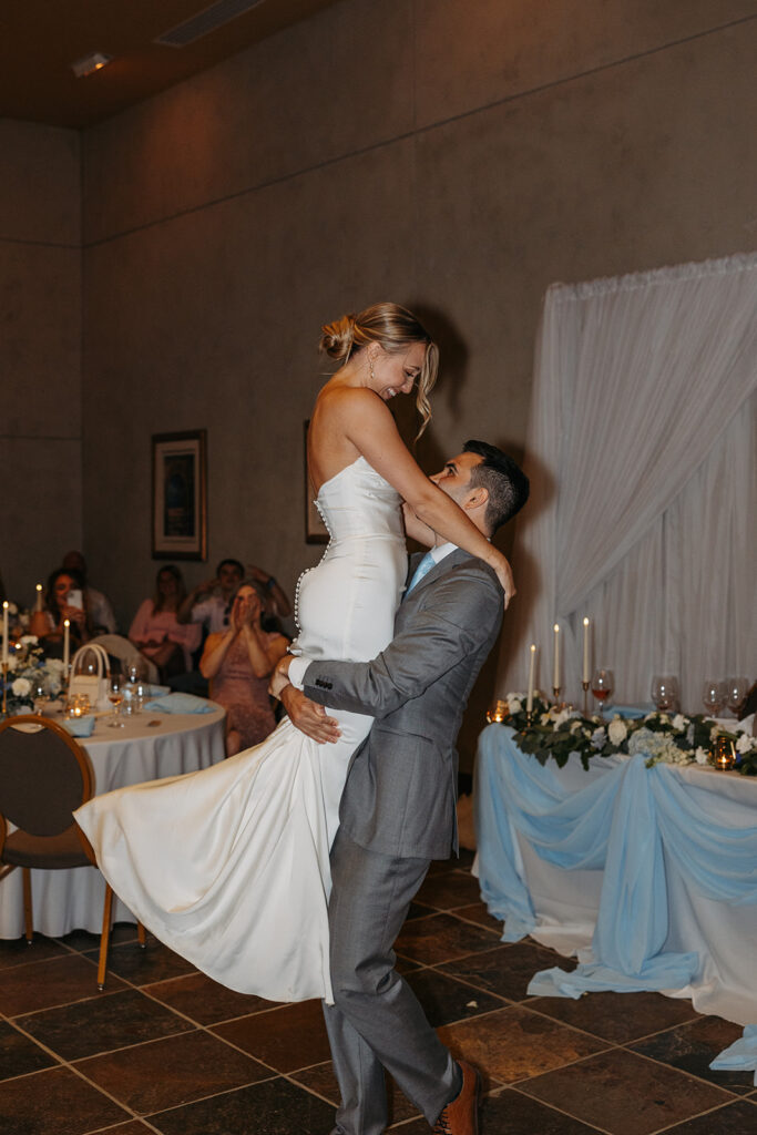 Couple’s fun first dance in a picturesque reception setting.