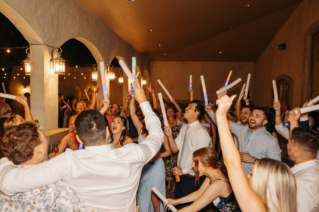 A fun and exciting wedding reception dance floor with glow sticks.