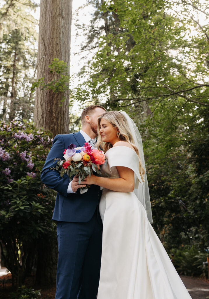 Bride and groom standing on a forested pathway near Kiana Lodge in Poulsbo, WA