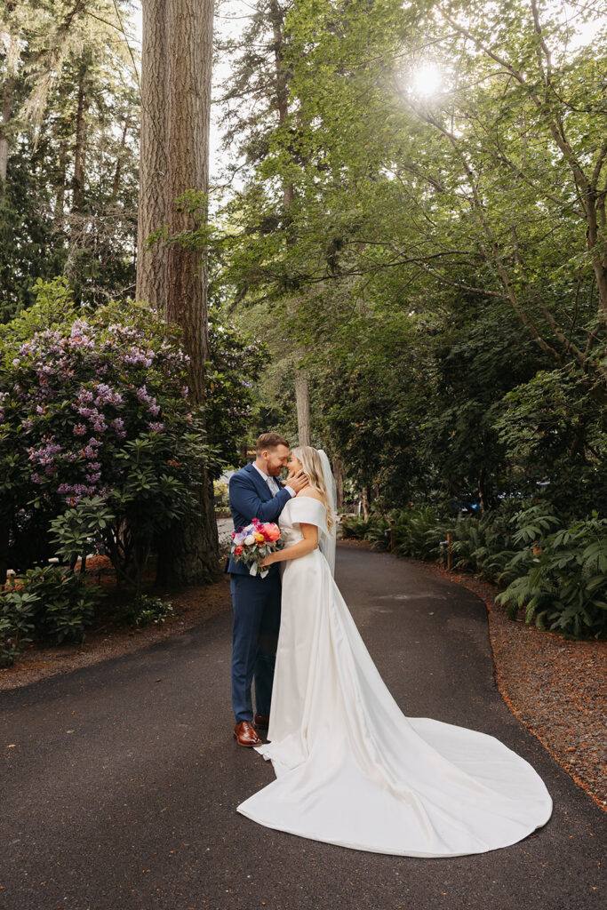 Bride and groom standing on a forested pathway near Kiana Lodge in Poulsbo, WA