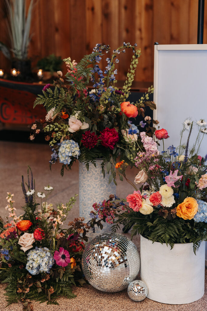 Stunning greenhouse-style wedding floral installation with a couple of disco balls