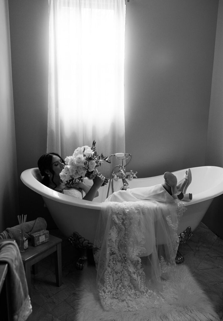 Bride lays in the vintage clawfoot bathtub in The Moore Mansion