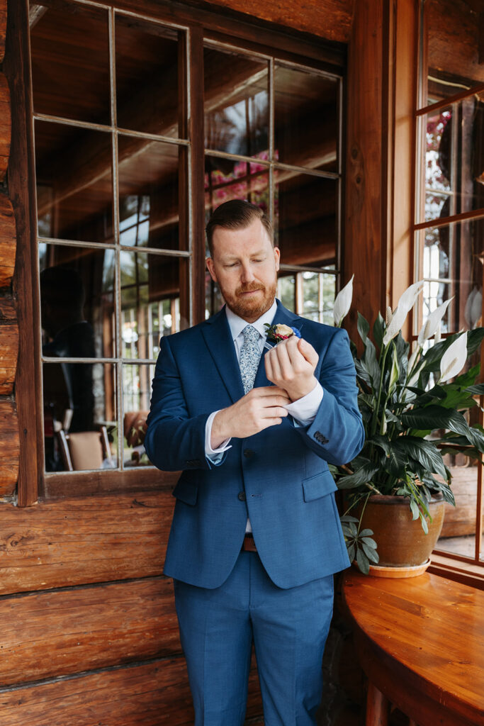 Groom adjust his shirt at the wrist before first look photos