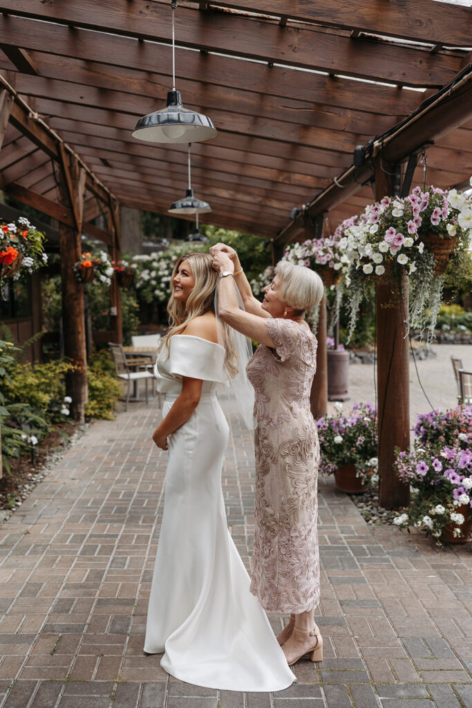 Mother helps the bride place her veil