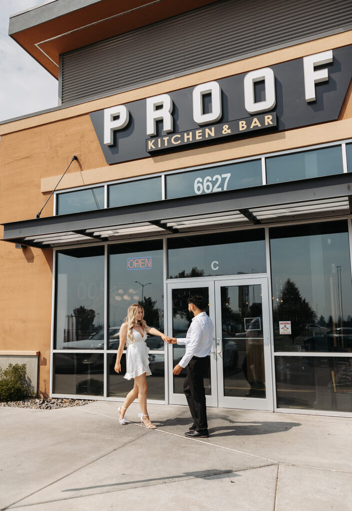 A couple walks outside of a bar during their classy engagement photos