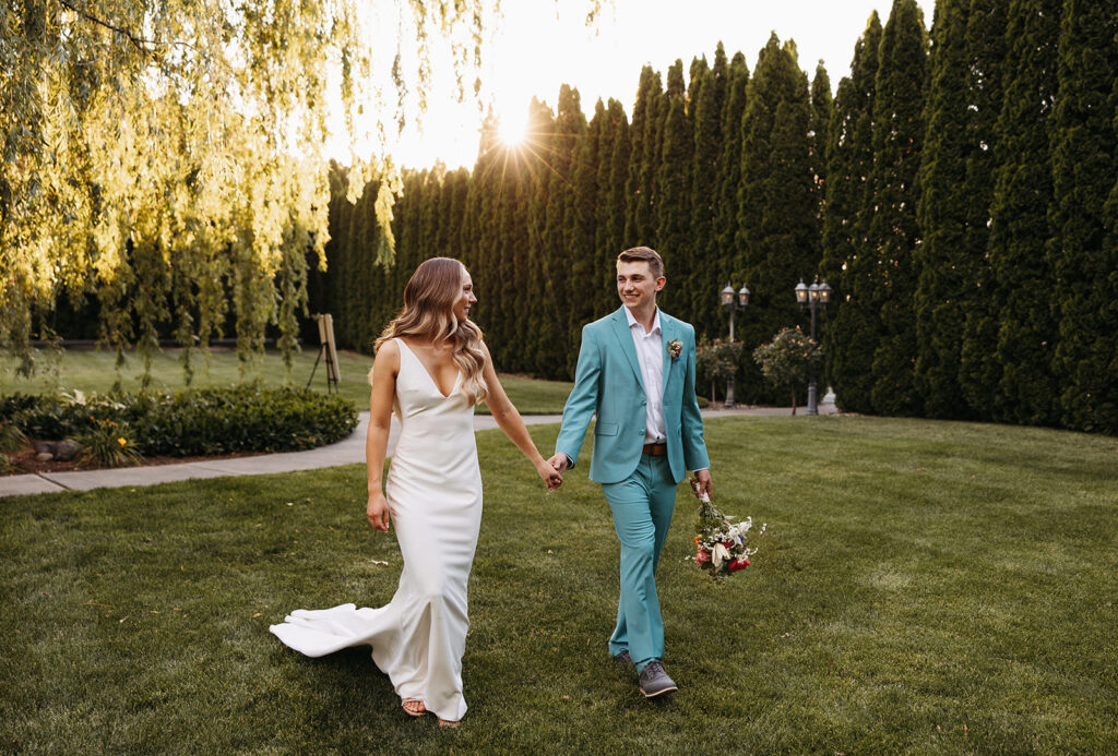 Bride and groom walk through the lawn at Promise Garden in Pasco