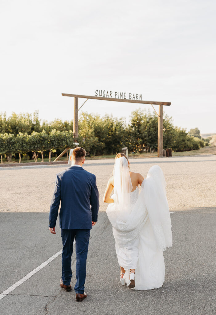 Bride and groom walk to the entrance of Sugar Pine Barn vineyard