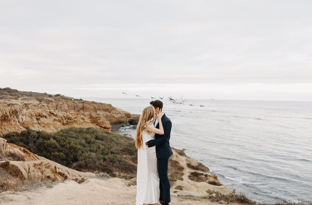 Sunset Cliffs elopement photos with seagulls flying in the backdrop