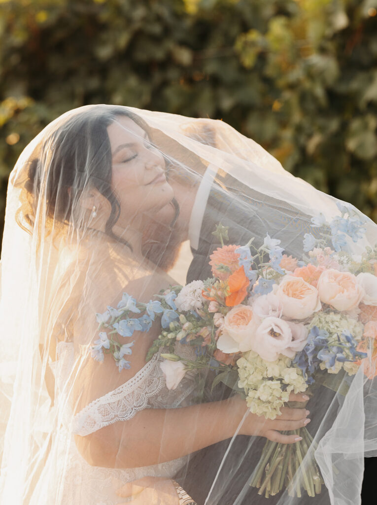Dreamy vineyard bride and groom photos with colorful bouquet