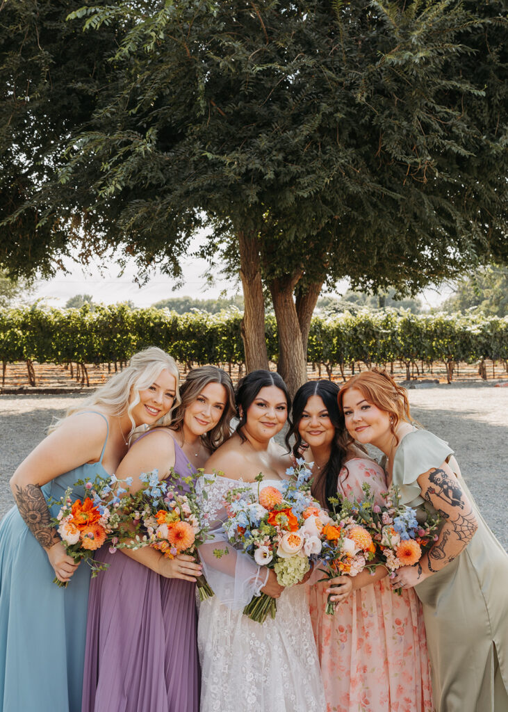 Bride and bridesmaids with colorful bouquets and bridesmaids dresses