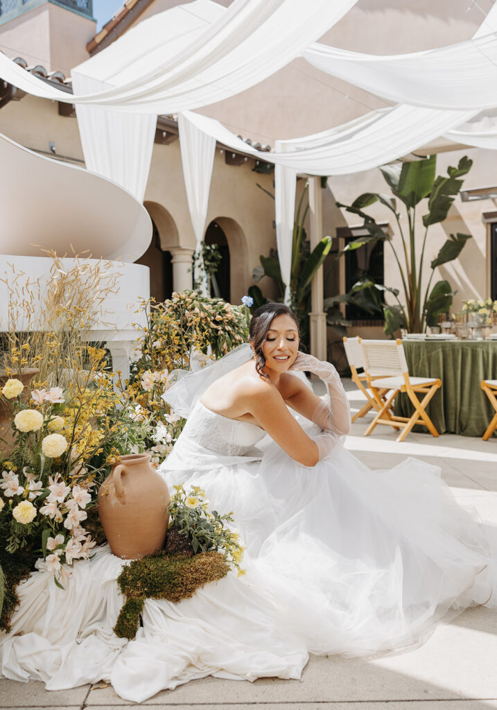 Bride seated in a layered tulle gown surrounded by floral textures and draped fabric during a Southern Bride editorial shoot in Temecula, California, captured in soft natural light.