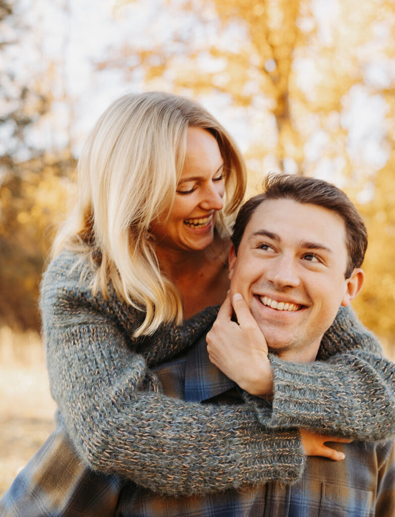 Couple sharing a close moment outdoors during an engagement session, photographed in a warm editorial wedding photography style.