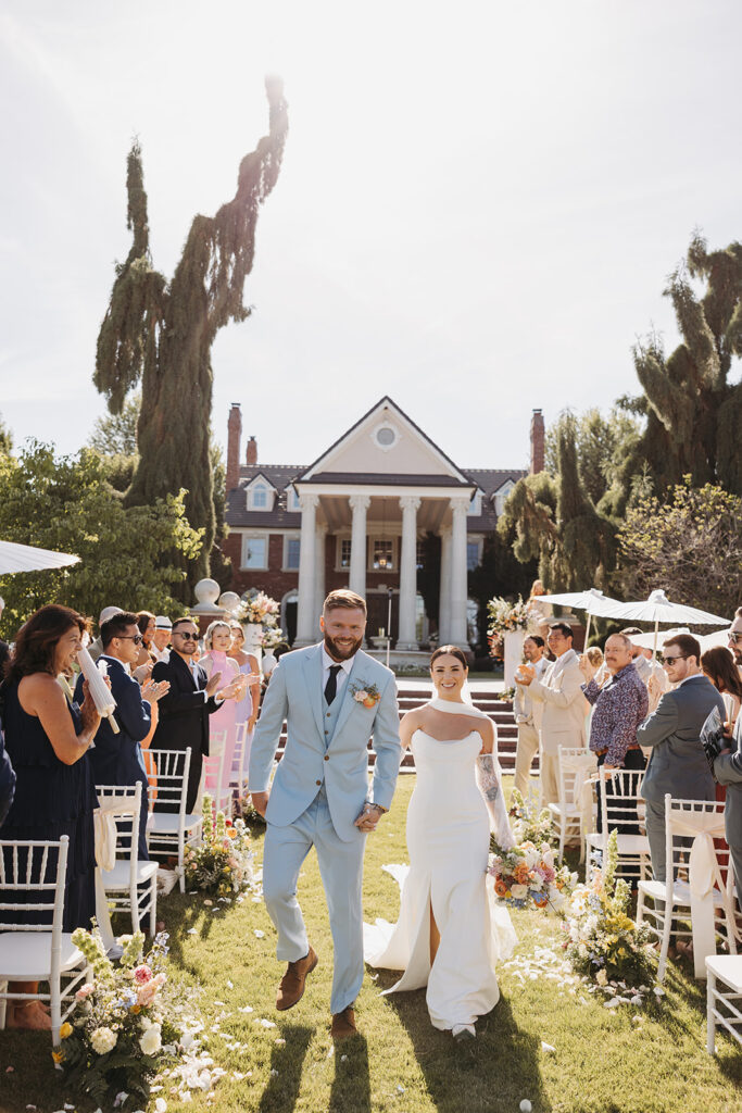 Bride and groom walking back up the aisle after their ceremony, photographed with an editorial wedding photography approach.