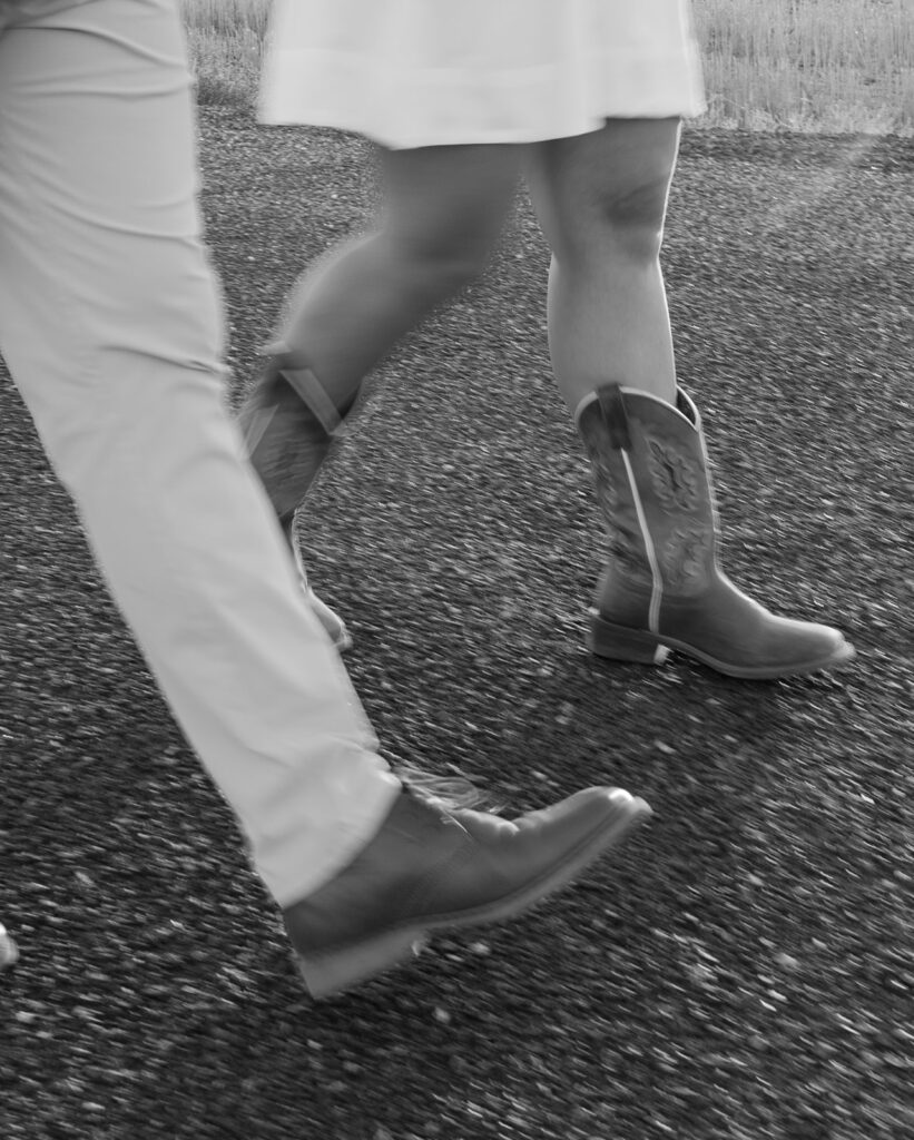 Black and white detail of a couple walking side by side, focusing on their steps and movement.