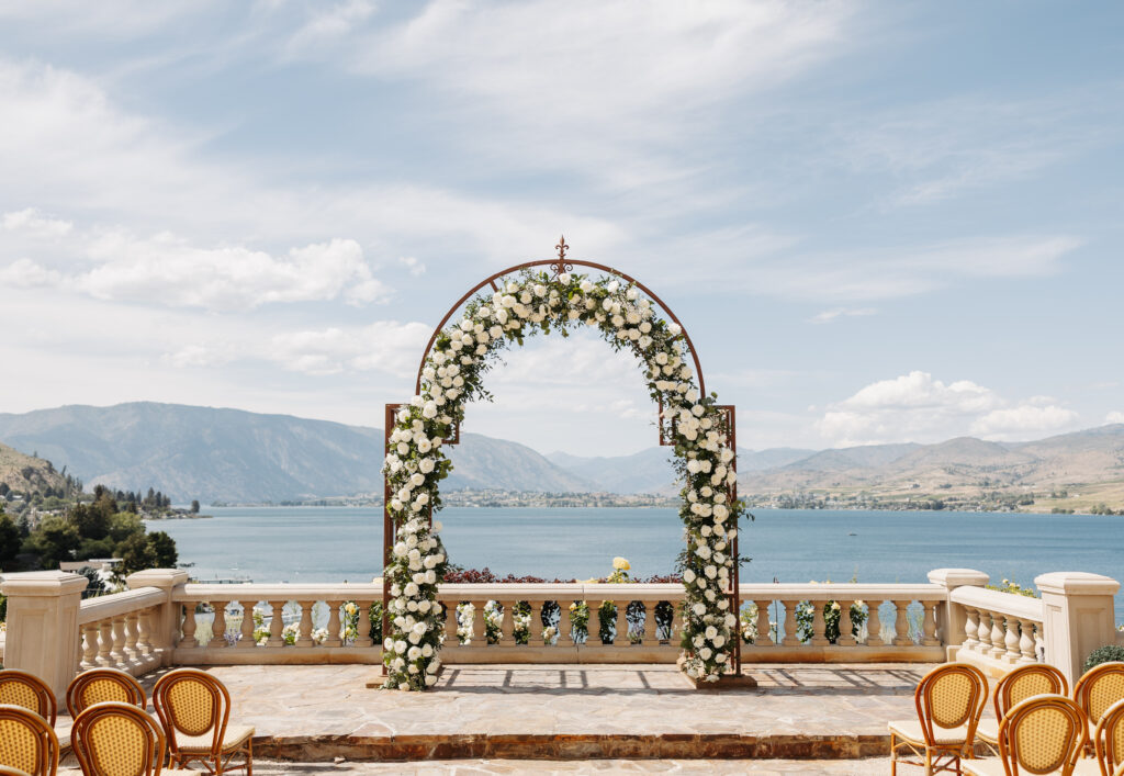 Luxury wedding ceremony at Siren Song Winery in Chelan with floral arch, lake views, and elegant terrace ceremony setup