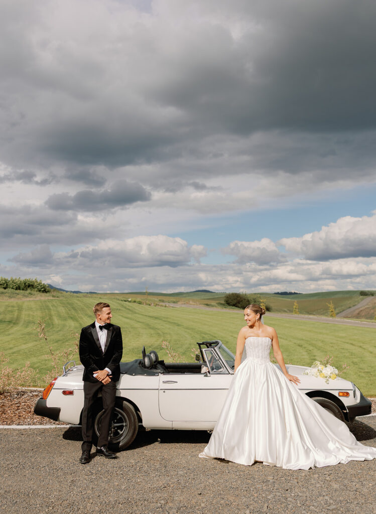 Bride and groom portraits at Greenhouse on Harvard with a vintage convertible and rolling green hills in the backdrop