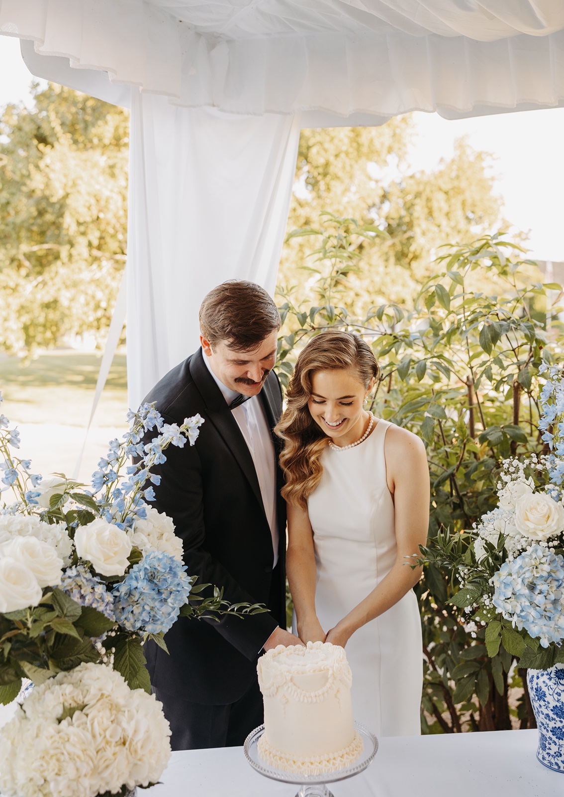 Bride and groom cut wedding cake at their Promise Garden wedding